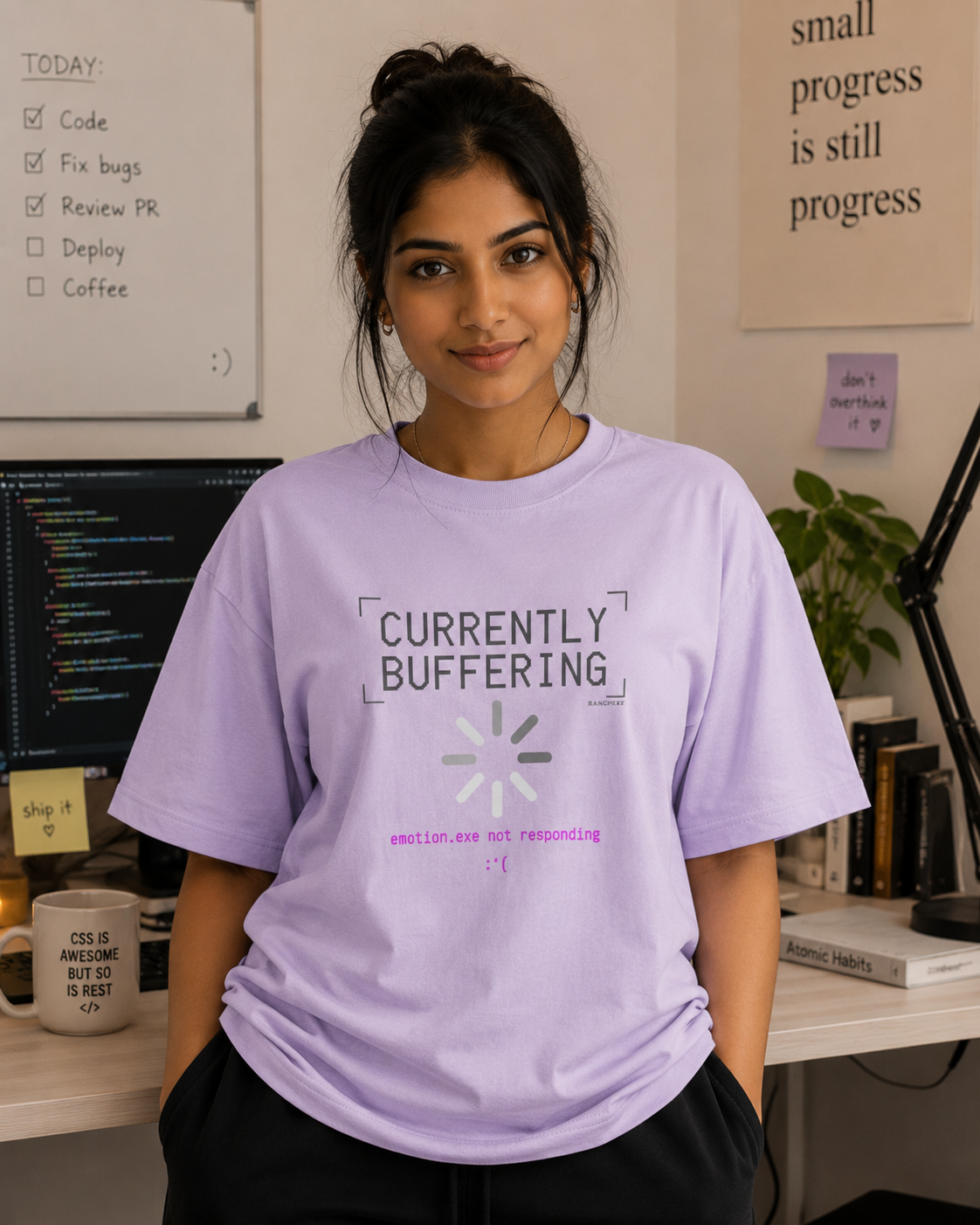 Person wearing a purple t-shirt with 'Currently Buffering' text in an office setting.